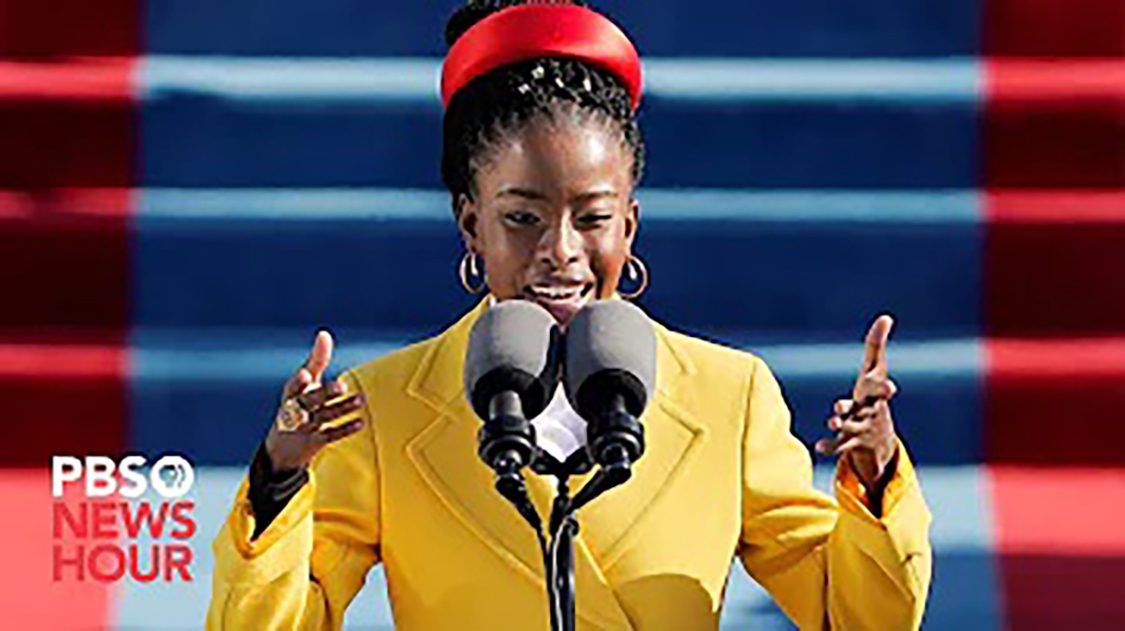 beautiful african american woman confidently speaking on the microphone while wearing a nice yellow suit and red hat
